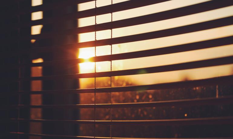 Window blinds open during sunset